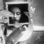 Photo of a young woman helmet diving with an angelfish, late 1940's